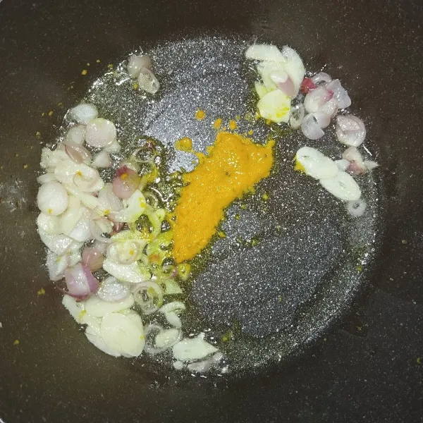 Dalam wajan tumis bawang merah, bawang putih dan kunyit yang sudah dihaluskan dengan garam, masak hingga harum.