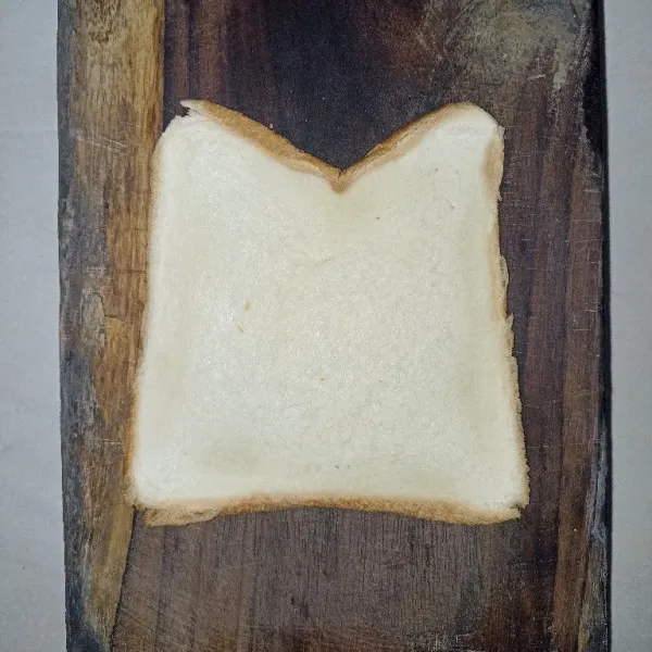 Siapkan 1 lembar roti tawar, gilas tipis dengan rolling pan.