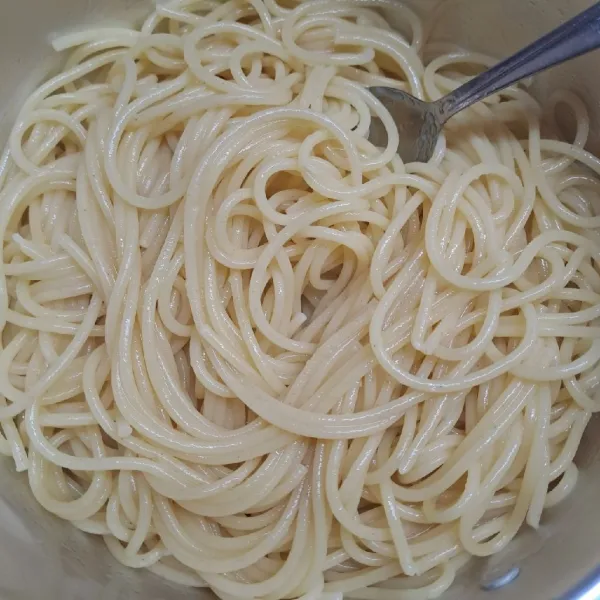 Tiriskan spaghetti, beri olive oil. Aduk rata agar tidak lengket.