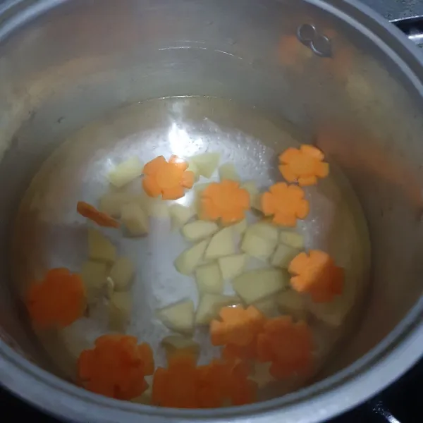 Didihkan air, masukan wortel, kentang dan bawang putih goreng