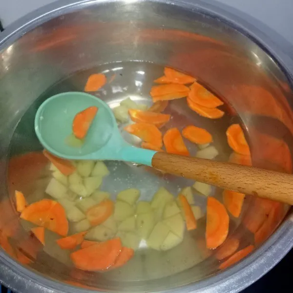 Rebus air untuk kuah hingga mendidih lalu masukkan wortel dan kentang masak hingga empuk