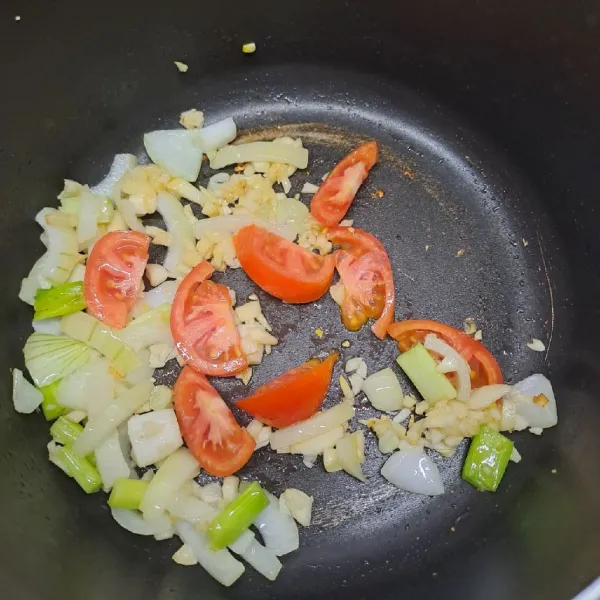 Tumis bawang putih, bombay dan daun bawang sampai layu dan harum. Masukkan irisan tomat.