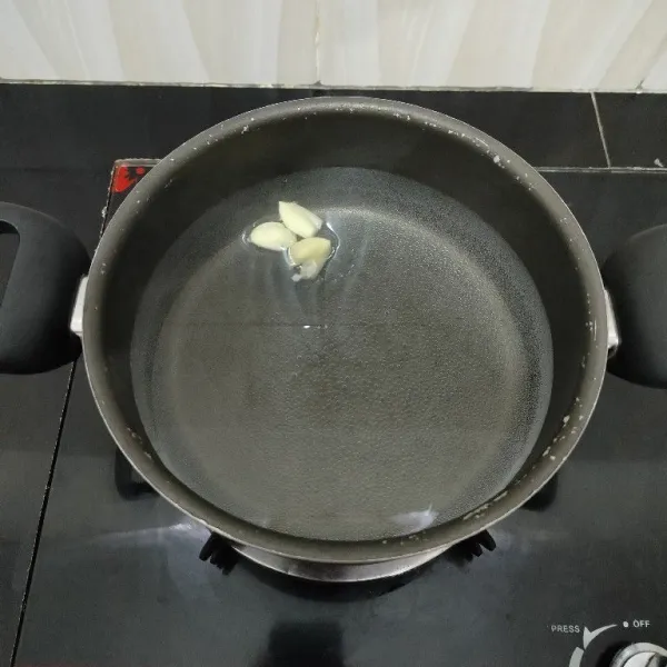 Rebus air dan bawang putih di dalam panci hingga mendidih.