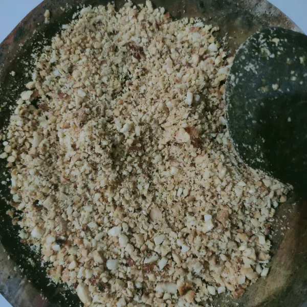Membuat isi, sangrai kacang tanah, buang kulit arinya, kemudian tumbuk.