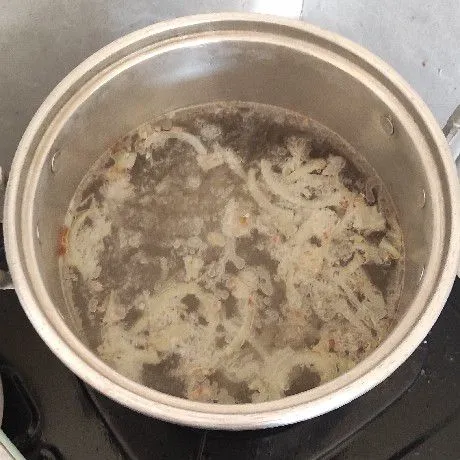 Masukan tumisan bawang, bumbui garam dan kaldu jamur bubuk ke panci air lalu rebus sampai mendidih