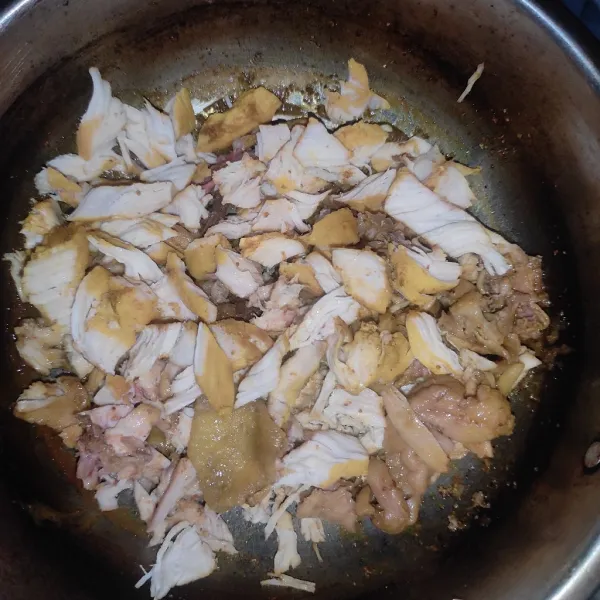 Tuang ayam kedalam wajan. Tambahkan bumbu marinasi dan air. Masak sampai matang. Lalu suwir-suwir ayam.