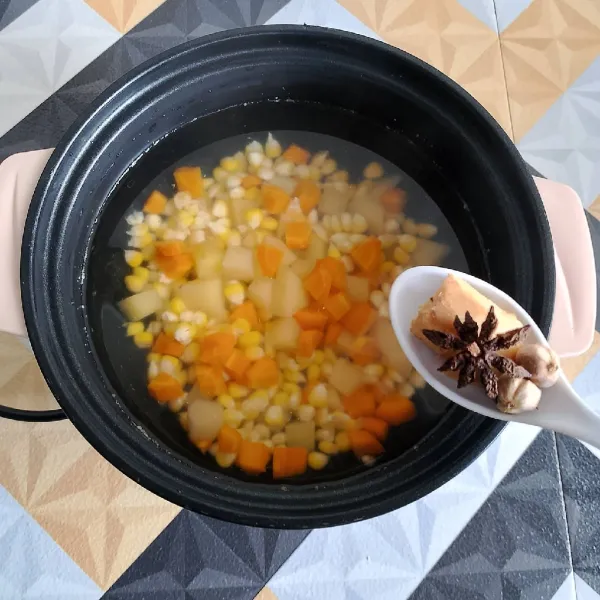 Rebusan air hingga mendidih, kemudian masukkan wortel, kentang dan jagung, masak hingga lunak. Kemudian masukkan jahe, bunga lawang dan kapulaga.