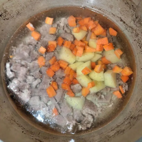 Kemudian setelah mendidih dan masukkan wortel dan kentang yang di iris sesuai selera aduk sampai rata