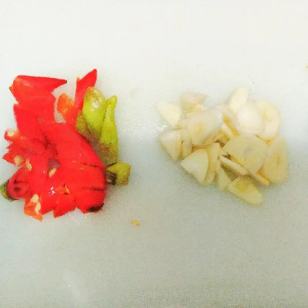 Bawang putih dan cabe rawit di potong kecil-kecil.