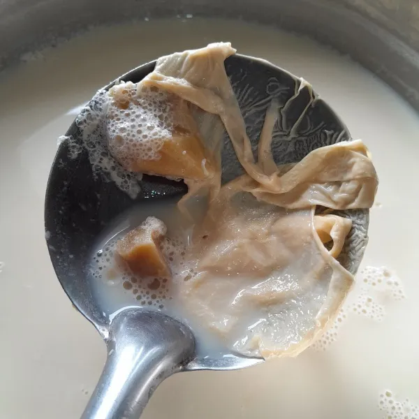 Biarkan susu kacang kedelai agak hangat, akan muncul lapisan di atas nya (seperti kulit tahu), angkat bagian tersebut dan buang. Susu kacang kedelai siap disajikan.