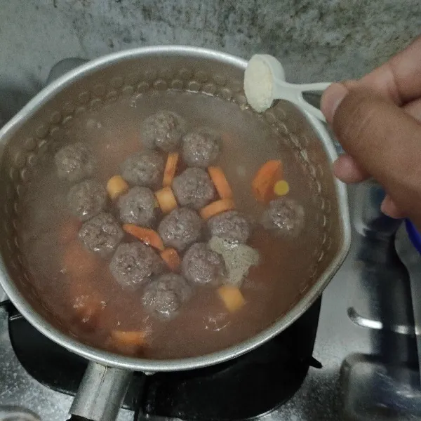 Tambahkan garam, lada bubuk, kaldu bubuk dan pala parut. Masak sampai bola daging dan wortel matang.