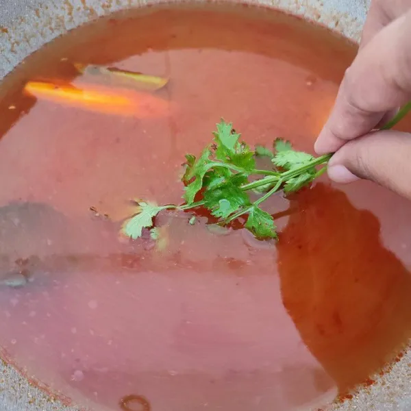 Tambahkan air kaldu udang dan daun ketumbar.