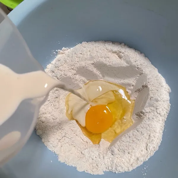 Buat lubang di tengah, masukkan telur dan susu cairnya bertahap. Uleni sampai tercampur rata dan kalis.