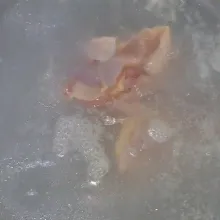 Didihkan air satu setengah liter, lalu masukkan daging ayam. Buang kotoran yang mengambang.