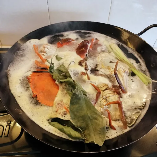 Didihkan air, lalu rebus kepiting bersama daun salam, jahe dan serai sampai berubah warna .Lalu tiriskan.