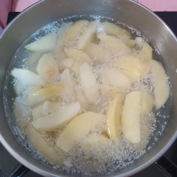 Potong-potong kentang memanjang.
Panaskan air, beri bawang putih parut dan garam. Masukkan kentang.
Rebus sebentar saja kemudian tiriskan.
