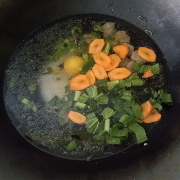 Tambahkan air, telur, wortel, sawi, masak hingga matang.