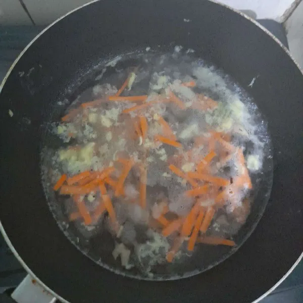 Tambahkan air lalu masukkan potongan wortel, masak hingga matang.