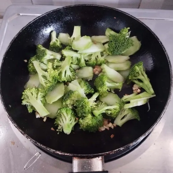 Masukkan bonggol brokoli. Tambahkan sedikit air, aduk, lalu masukkan brokoli.