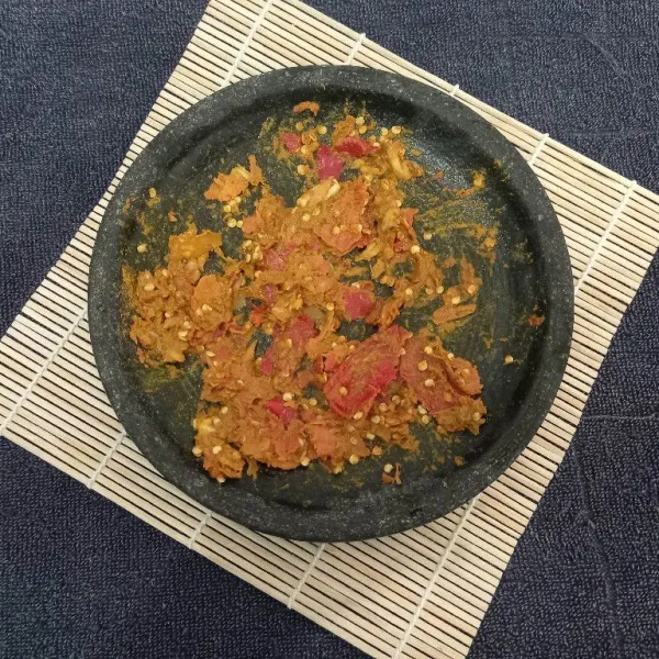 Haluskan bumbu menggunakan cobek.