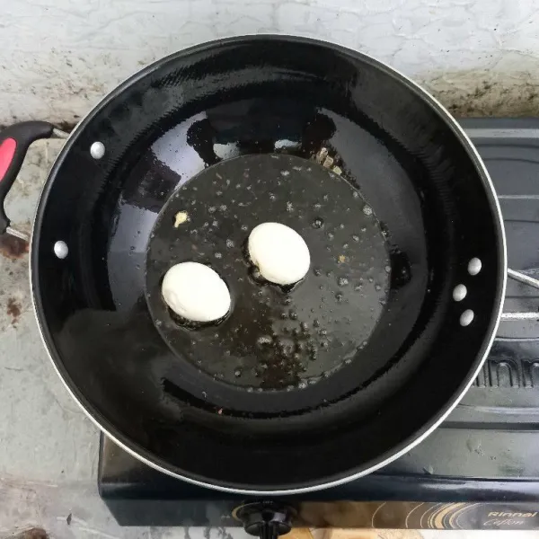 Goreng dua butir telur sampai kecokelatan.