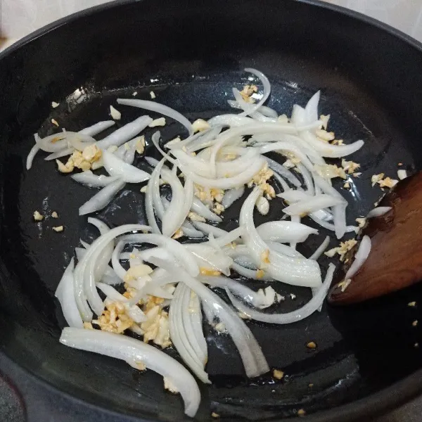 Panaskan minyak goreng, tumis bawang putih sampai mulai kecoklatan, kemudian masukkan bawang bombay, tumis sampai bawang bombay harum dan layu.