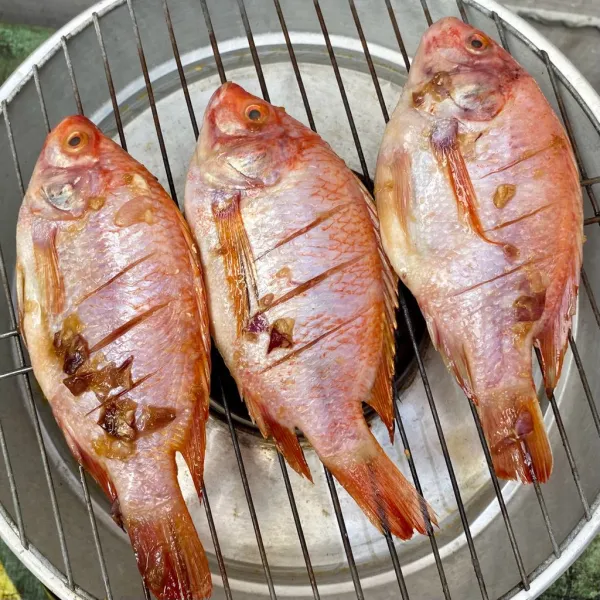 Siapkan alat bakaran, lalu bakar ikan yang telah diolesi margarin.