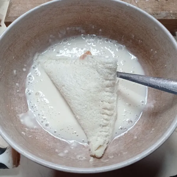 Masukan tepung terigu dan air kedalam wadah, aduk sampai dapat adonan pas, lalu celupin roti tawar.