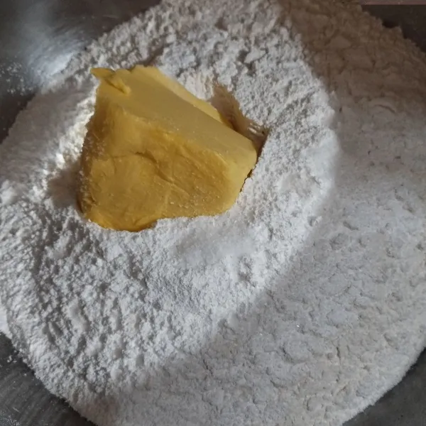 Dalam wadah, masukkan tepung terigu, gula halus, margarin, dan baking powder.