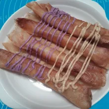 Tata pisang kulit lumpia dalam piring, lalu beri toping glaze tiramisu dan taro.