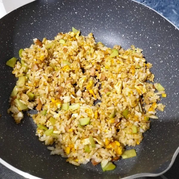 Beri garam, penyedap, kecap manis dan lada bubuk. Aduk rata. Masak sampai bumbu meresap dan matang. Kemudian matikan kompor, nasi goreng siap disajikan.