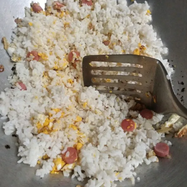 Masukkan nasi, tambahkan garam, kaldu bubuk dan lada bubuk. Aduk sampai tercampur rata.