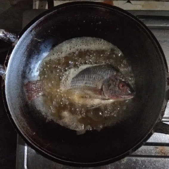 Goreng ikan mujair dengan minyak hingga matang kecokelatan.