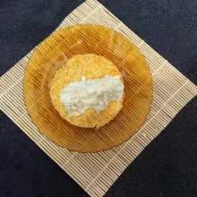Nugget yang sudah dibalurkan ke dalam adonan tepung, lalu balurkan ke tepung roti sampai rata.