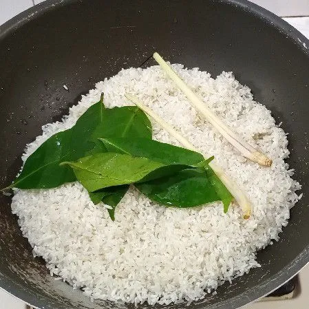 Cuci beras pindahkan ke wajan beri daun salam, serai dan garam.