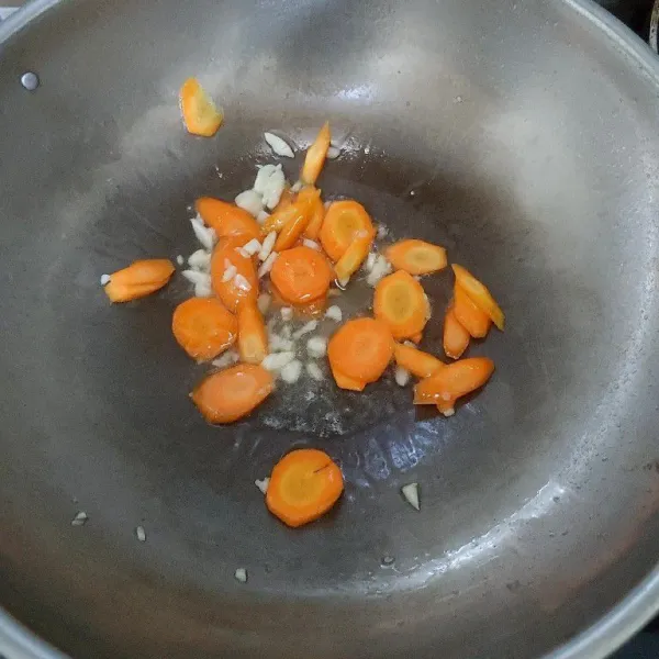 Tumis bawang putih hingga harum, lalu masukan wortel aduk rata.