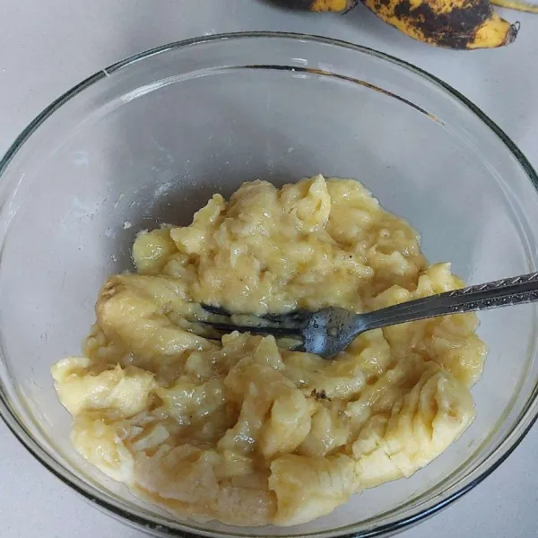 Hancurkan pisang menggunakan garpu.