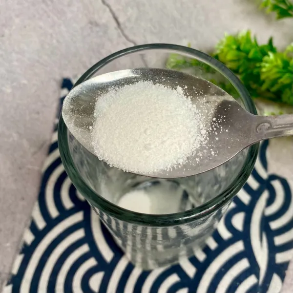 Siapkan gelas saji, lalu larutkan bubuk kelapa muda dengan 100 ml air.