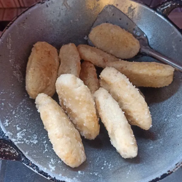 Selanjutnya masukkan kue getas aduk hingga semua bagian terselimuti dengan gula.