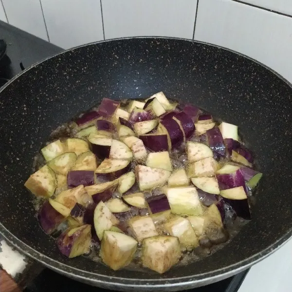 Potong terong sesuai selera lalu goreng sebentar, angkat dan tiriskan.