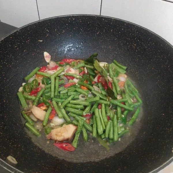 Masukan kacang panjang, tambahkan sedikit air lalu masak hingga layu.