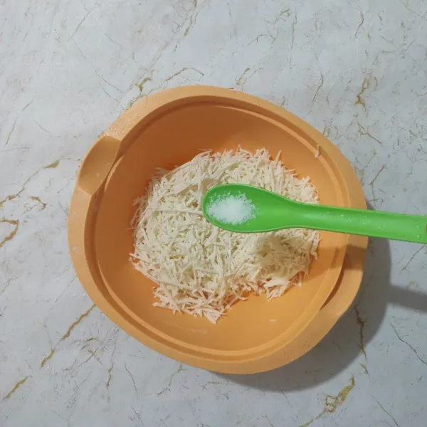 Tambahkan serutan singkong dengan garam, aduk rata.