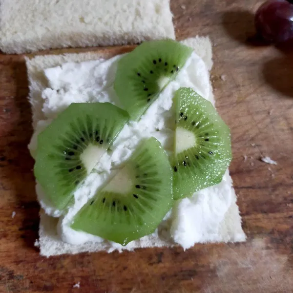 Tambahkan whip cream dan buah sesuai selera, ratakan.