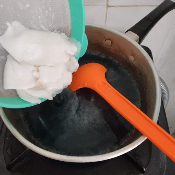 Masukkan daging kelapa muda, aduk merata dan masak sebentar, kemudian matikan kompor dan tunggu sampai uap panas hilang.