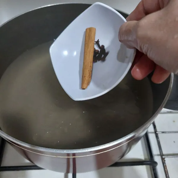 Panaskan kaldu dan air, tambahkan kayu manis dan cengkeh.