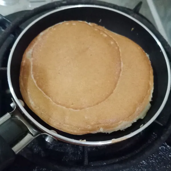 Balik adonan, masak satu sisinya hingga matang.Angkat. Ulangi hingga seluruh adonan habis. Sajikan pancake pisang bersama potongan buah pisang dan madu.