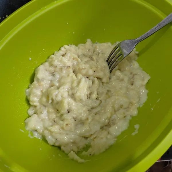 Kupas kulit pisang masukan ke dalam wadah lalu lumatkan pisang dengan garpu.