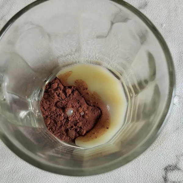 Dalam gelas lain, campurkan cokelat bubuk dan krimer.