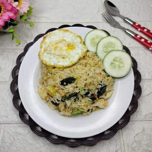 Pindahkan nasi goreng ke piring. Sajikan hangat dengan pelengkap telur ceplok dan timun.