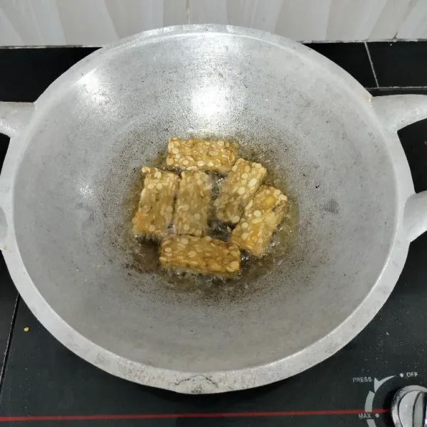 Potong-potong tempe, rendam sebentar dalam air garam, lalu goreng hingga matang, angkat dan tiriskan.